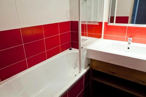 een badkamer met een wit bad en een wastafel bij Résidence Le Britania - maeva Home - Appartement 2 pièces 4 personnes - Pr 534 in Saint-Bon-Tarentaise