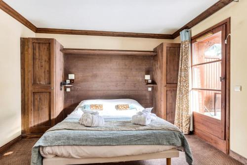 - une chambre avec un lit avec deux chats assis dans l'établissement Résidence Les Arcs 1950 Le Village - maeva Home - Appartement 2 pièces 4 personnes - Sélection MAE-0524, à Bourg-Saint-Maurice