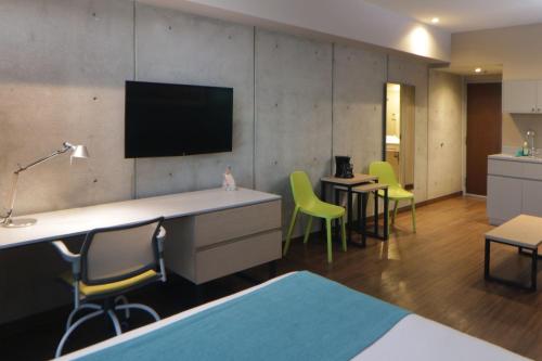 a room with chairs and a tv on a wall at City Express Suites by Marriott Tijuana Rio in Tijuana