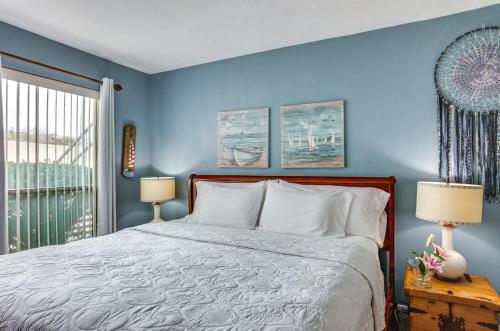 a blue bedroom with a bed and a window at Resort-Style Lake Conroe Retreat with Balcony and View in Willis