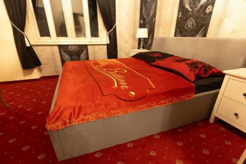een slaapkamer met een bed met een rode deken erop bij Villa Orasch mit Erotikflair in Krumpendorf am Wörthersee