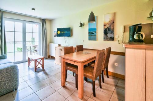 a kitchen and dining room with a wooden table and chairs at Résidence Belle Dune - maeva Home - Appartement 2 pièces 4 personnes - Sélection MAE-9334 in Fort-Mahon-Plage