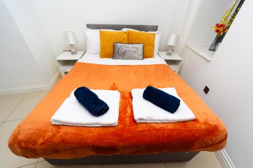 1 dormitorio con 1 cama con 2 almohadas azules en Spacious Flat with Patio & Parking in city centre en Reading