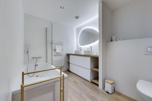 a white bathroom with a sink and a mirror at Résidence Les Alpages - Pièces 884 in La Rosière