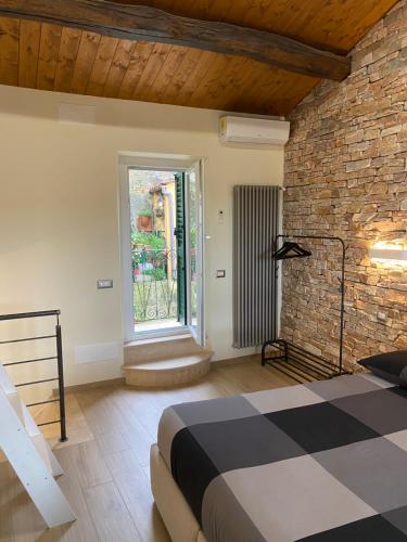 - une chambre avec un lit et un mur en briques dans l'établissement DOLCE VITA, à Vignanello