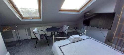 Pokój z łóżkiem, stołem i telewizorem w obiekcie Serene Homes Sheffield, Private Ensuite Velux Room w mieście Hillsborough