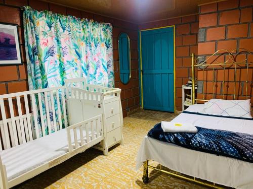 a bedroom with two twin beds and blue doors at Finca turística VILLA OFELIA in Quimbaya