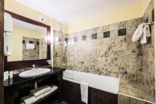 une salle de bain avec une baignoire et un lavabo et une baignoire tubermottermott dans l'établissement Résidence Les Arcs 1950 Le Village - maeva Home - Appartement 2 pièces 6 personnes - Sélection MAE-6904, à Bourg-Saint-Maurice