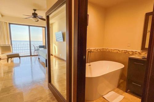 a bath tub in a bathroom with a view of the ocean at Seaview Oasis 1-BR Suite in Croc's casino resort in Jacó