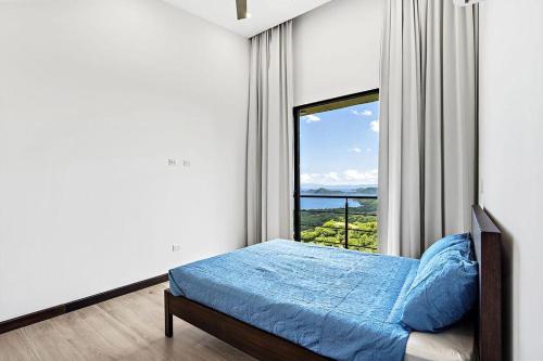 sypialnia z łóżkiem i dużym oknem w obiekcie Casa del Buho w mieście Playa Hermosa