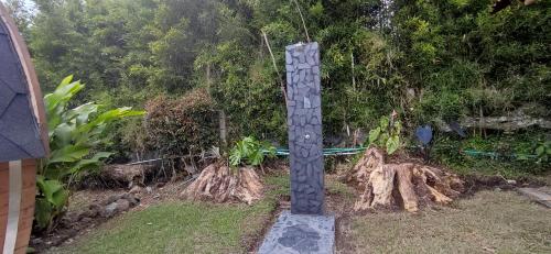 un totem nel mezzo di un cortile con alberi di Cabaña en el corazón del Eje Cafetero, Sauna terapéutico a Filandia
