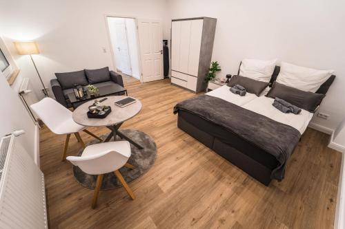 - une chambre avec un lit, une table et un canapé dans l'établissement Weserzauber: 1-Zimmer City-Apartment in Bremen, à Brême