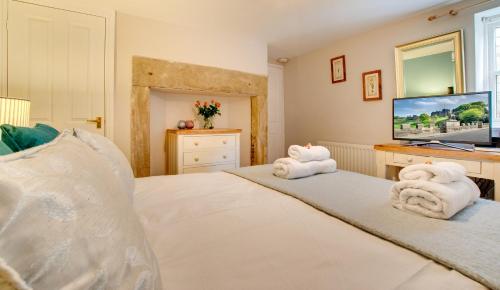 a bedroom with a bed with towels on it at Barbican View - luxury apartment opposite Alnwick Castle in Alnwick