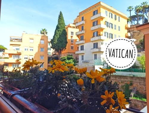 a planter with yellow flowers in front of a building at Have a nice stay in Rome 2 in Rome