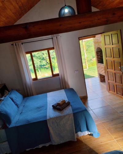 a bedroom with a bed with a blue comforter at Chalés Encantos de Minas in Bueno Brandão