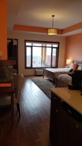 a living room with a bed and a large window at Hillcrest Farm Market B&B in Kelowna