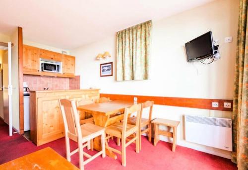 une cuisine et une salle à manger avec une table et des chaises dans l'établissement Résidences quartier Charmettoger - maeva Home - Appartement 2 pièces 5 personnes - Budget MAE-2384, à Arc 1800