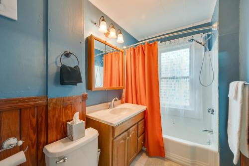 baño con cortina de ducha naranja y lavamanos en Easthampton Vacation Rental Near Mill Buildings!, en Easthampton