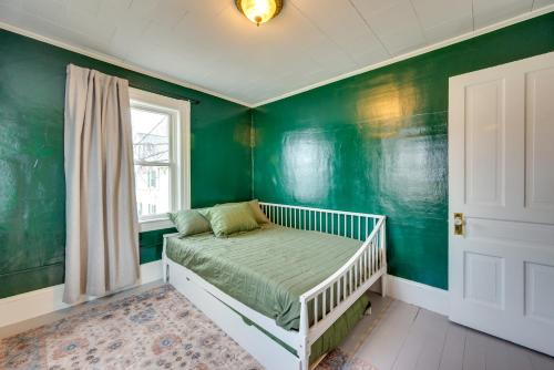 um quarto verde com um berço e uma janela em Easthampton Vacation Rental Near Mill Buildings! em Easthampton