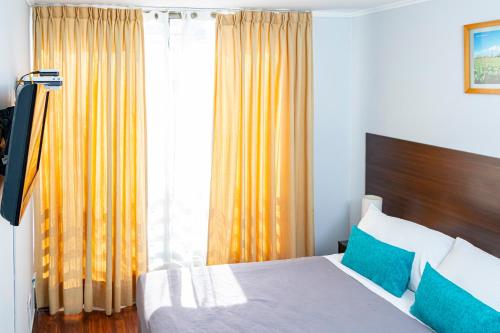 a hotel room with a bed and a window at Departamentos Amoblados Torre Tagle in Santiago