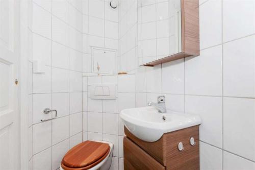 a white bathroom with a toilet and a sink at Pepes Apartment in Bergen