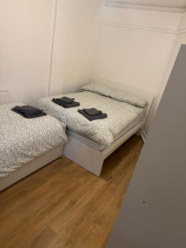 two beds in a room with white walls and wooden floors at one bedroom apartment in Tower Bridge road in London
