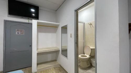 a bathroom with a toilet and a tv on the wall at Hotel Balcon de Oro Curumani in Curumaní