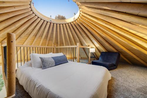 1 dormitorio con 1 cama y 1 silla en una yurta en Estelle - Freedom Yurt Cabins, en Canyon Lake