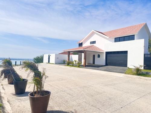 una casa bianca con palme di fronte alla spiaggia di Residencia Exclusiva y Privada - Con Vistas Increíbles a Veracruz