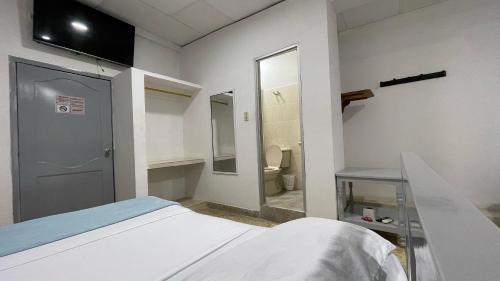 a hospital room with a bed and a bathroom at Hotel Balcon de Oro Curumani in Curumaní