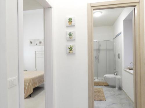 a white bathroom with a toilet and a sink at Casa Lumìa in Palermo