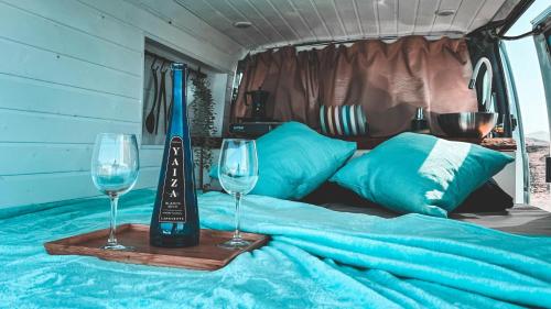 dois copos de vinho numa cama num trailer em Camperita Van Life em Puerto del Carmen