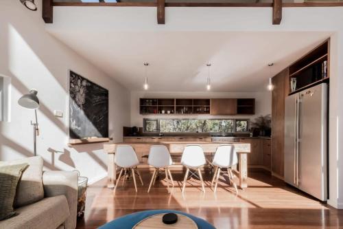 a living room with a kitchen with a table and chairs at Mr Wooden Box Bush Retreat 5 minutes from the CBD in Inveresk