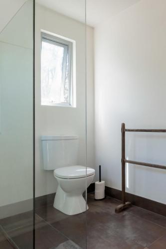 a bathroom with a toilet and a window at Mr Wooden Box Bush Retreat 5 minutes from the CBD in Inveresk