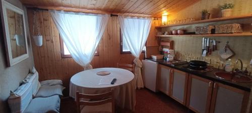 Una pequeña cocina con una mesa y un fregadero. en Nice studio 2 steps from the slopes, en Saint-Chaffrey
