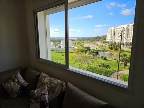 a living room with a large window with a couch at Beachfront Gorgeous Flat in Tangier in Tangier