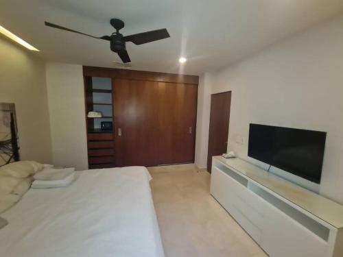 a bedroom with a bed and a flat screen tv at Moderno departamento en Playa del Carmen in Playa del Carmen