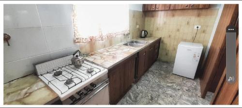 uma cozinha com um fogão e um lavatório em LA CASA DE LILI Y JAVIER em Villa María