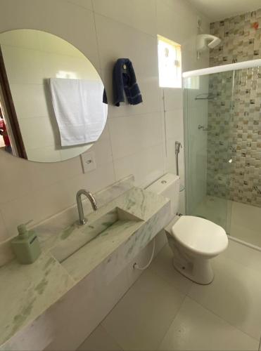 a bathroom with a sink and a toilet and a mirror at Espaço d Lurdes in Piranhas