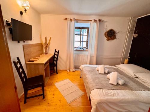 - une chambre avec 2 lits, un bureau et une fenêtre dans l'établissement Schiller Haus&Restaurant, à Spišská Belá