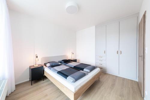 a bedroom with a large bed and white cabinets at Residence Mozaika in Prague