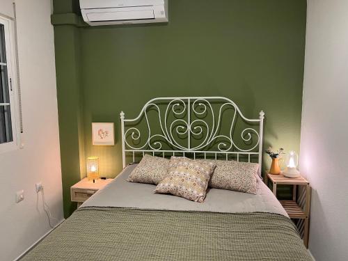 een slaapkamer met een bed met een groene muur bij Casa Quijote in Granada