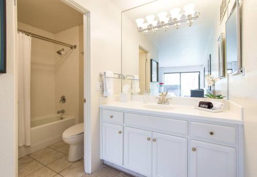 a white bathroom with a sink and a toilet at Napa Valley Golf View Condo in Silverado in Napa