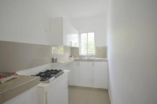 a kitchen with white cabinets and a stove top oven at Au milieu de la nature au calme in Las Terrenas
