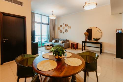 uma sala de estar com uma mesa de madeira e cadeiras em Cozy 1 Bedroom in the heart of Dubai Marina em Dubai