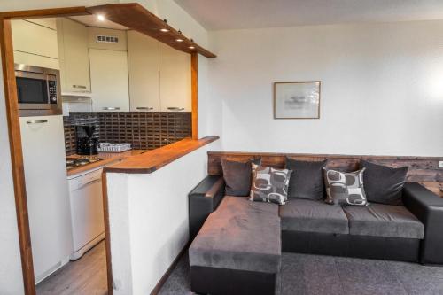 un salon avec un canapé et une cuisine dans l'établissement Résidence Le Belvedere - Appartement 2 pièces au coeur des Orres 1650 MAE-6294, aux Orres