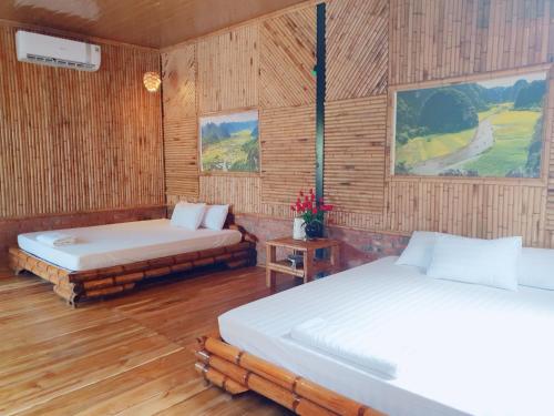 - 2 lits dans une chambre dotée de murs en bois dans l'établissement Trang An Quynh Trang Happy Homestay & Garden, à Ninh Binh