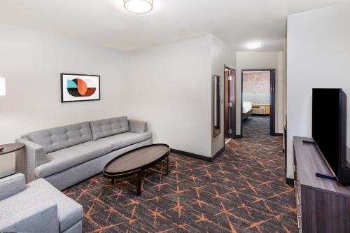 a living room with a couch and a tv at Holiday Inn Hotel & Suites Tulsa South by IHG in Tulsa