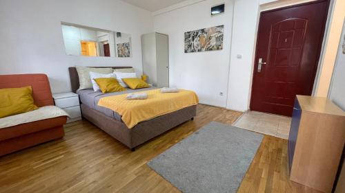 a bedroom with a bed and a couch and a red door at Voždovac Vitanovacka in Belgrade
