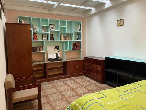 1 dormitorio con 1 cama, escritorio y estanterías en Tumbaco Ritz, en Quito